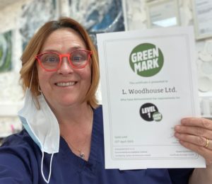 Sukie Woodhouse holding the business' Green Mark certificate 